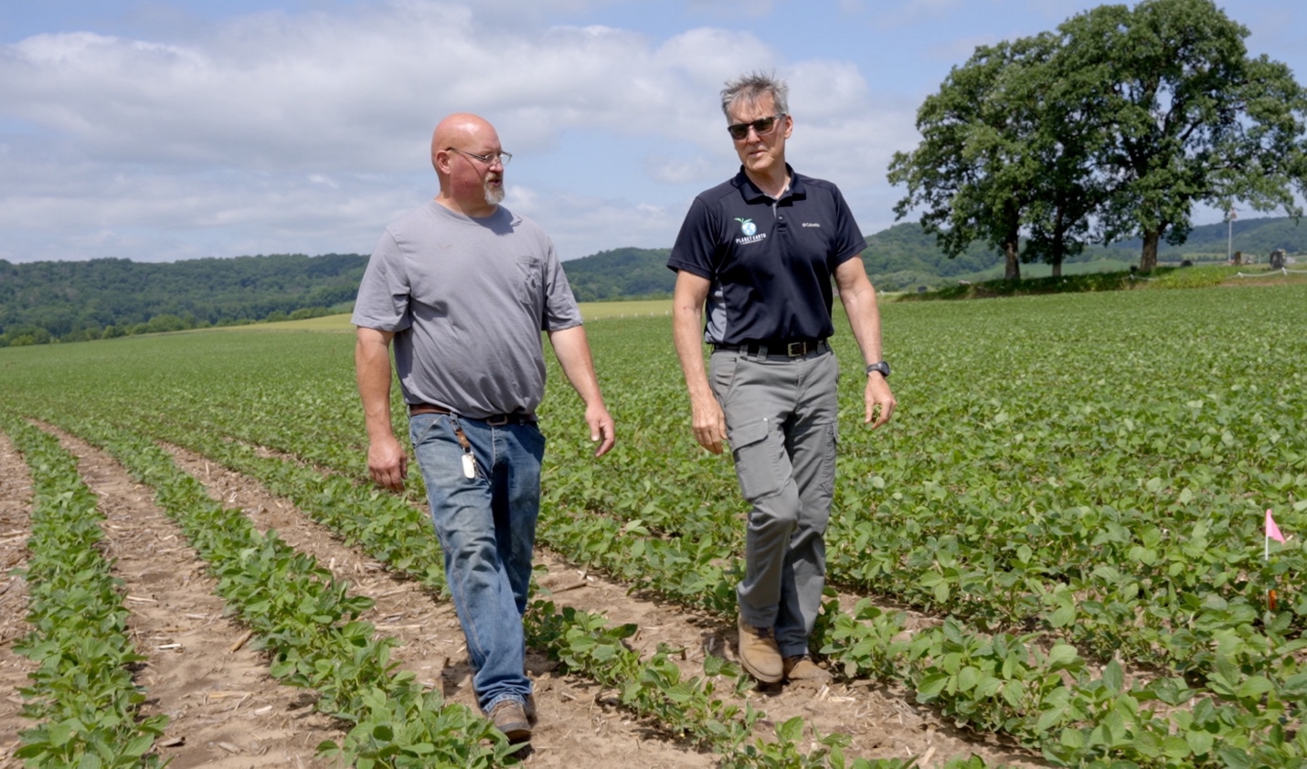 Josh Biser and Larry Fiene walking through a Premier Ag soybean test plot